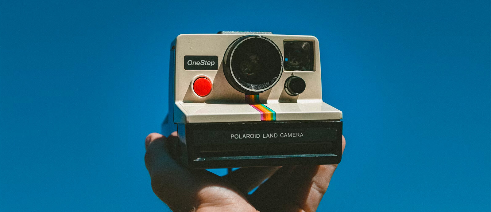 A collection of vintage cameras and gadgets arranged on a shelf