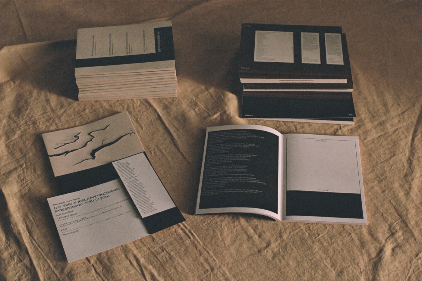 Stacked brand guideline booklets and paper swatches on bone linen
